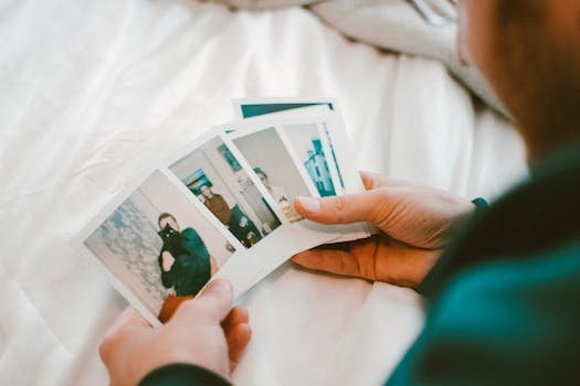 pexels-photo-1807891-1807891 Hands holding a collection of vintage polaroid photos, capturing cherished memories in a cozy indoor setting.