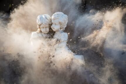 Intricate stone statues engulfed in a dynamic dust explosion, creating a dramatic artistic effect.